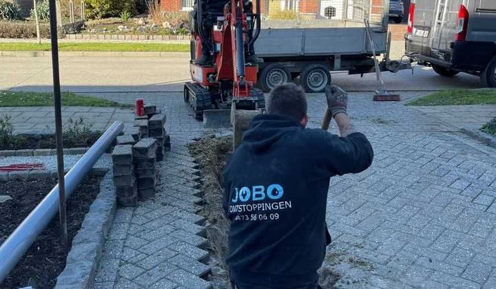 Rioleringswerken met minigraver in een woonstraat