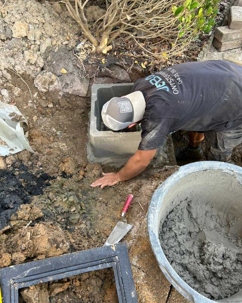 Technieker van Jobo Ontstoppingen voert rioleringswerken uit en metselt een nieuwe inspectieput.